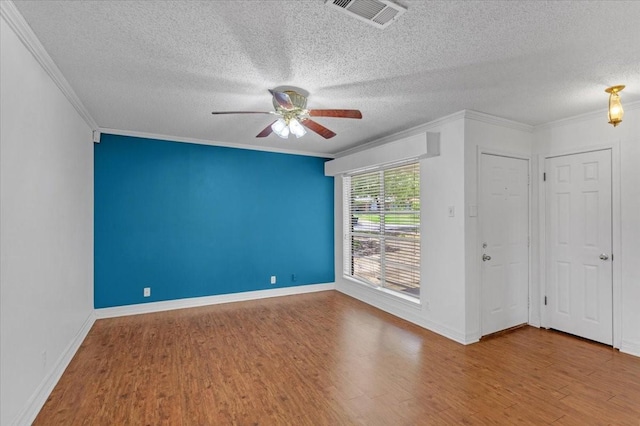 unfurnished room with wood-type flooring, a textured ceiling, ceiling fan, and ornamental molding