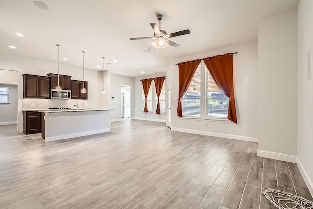 unfurnished living room with ceiling fan and light wood-type flooring