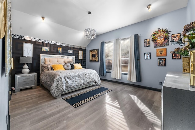 bedroom featuring vaulted ceiling, dark wood-type flooring, and a notable chandelier