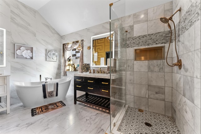 bathroom featuring vanity, separate shower and tub, lofted ceiling, and tile walls