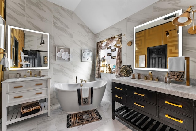 bathroom with a bathing tub, vanity, tile walls, and vaulted ceiling