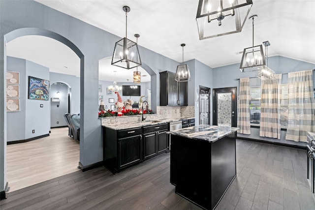 kitchen with decorative backsplash, a center island, dark hardwood / wood-style floors, and decorative light fixtures