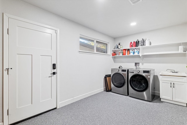 laundry area featuring cabinets, separate washer and dryer, and sink