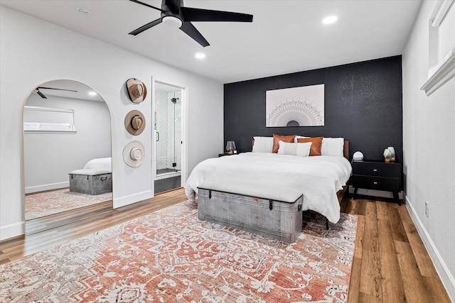 bedroom featuring connected bathroom, ceiling fan, and hardwood / wood-style floors