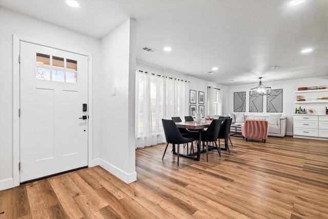 entrance foyer with light hardwood / wood-style flooring and a chandelier