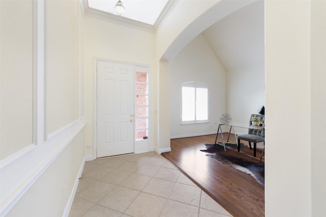 foyer entrance with light tile patterned floors and ornamental molding