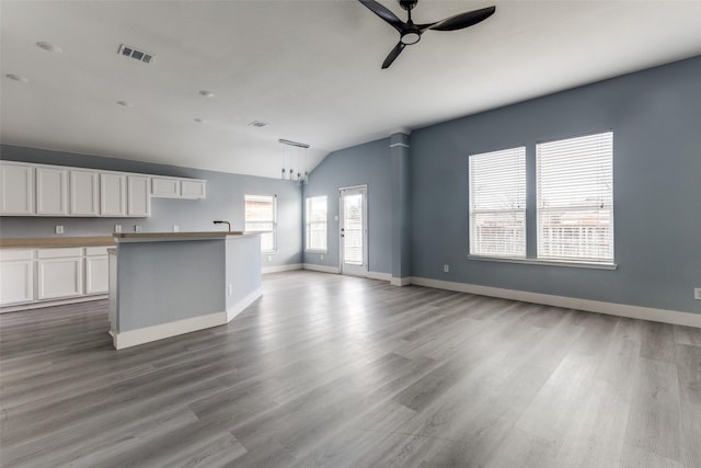 unfurnished living room with light wood-type flooring, ceiling fan, and lofted ceiling