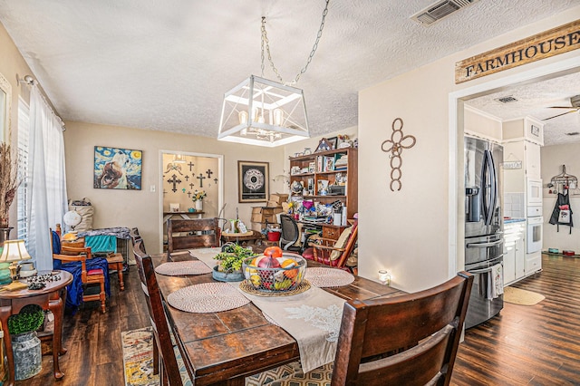 dining area with ceiling fan, dark hardwood / wood-style flooring, and a textured ceiling