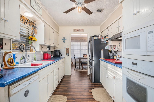 kitchen featuring a textured ceiling, white cabinetry, white appliances, and sink