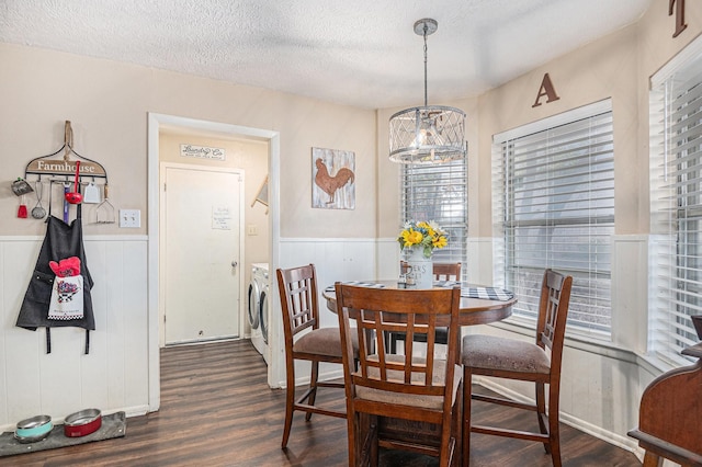 dining area with a textured ceiling, dark hardwood / wood-style floors, washer / clothes dryer, and a notable chandelier