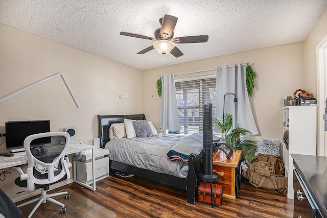 bedroom with ceiling fan, dark wood-type flooring, and a textured ceiling