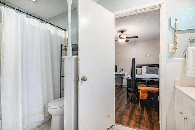 bathroom with vanity, tile patterned floors, ceiling fan, toilet, and a textured ceiling