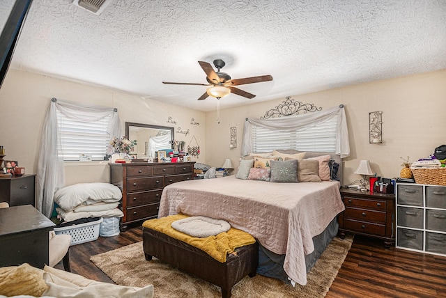 bedroom with ceiling fan, dark hardwood / wood-style floors, and a textured ceiling