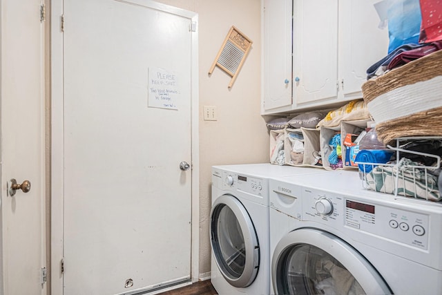 clothes washing area with washer and dryer and cabinets