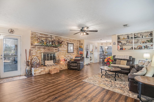 living room with a fireplace, hardwood / wood-style floors, a textured ceiling, and ceiling fan