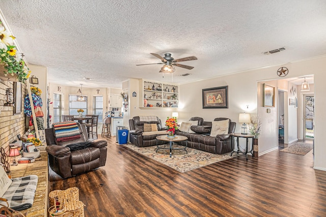 living room featuring ceiling fan, dark wood-type flooring, and a textured ceiling