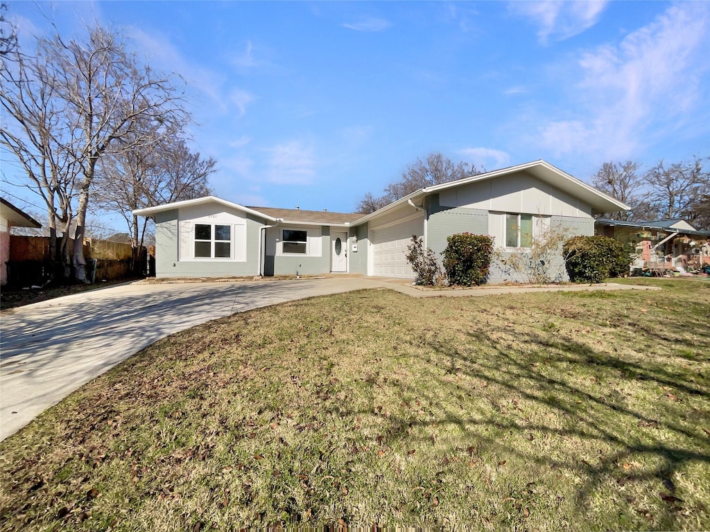 ranch-style home featuring a garage and a front lawn