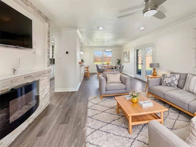 living room with a fireplace, hardwood / wood-style floors, ceiling fan, and ornamental molding