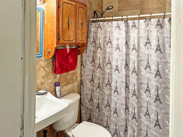 bathroom with toilet, curtained shower, and sink