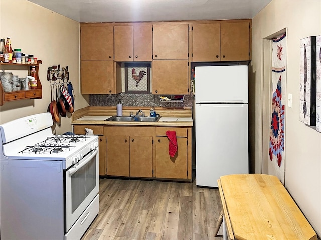 kitchen featuring tasteful backsplash, sink, white appliances, and light hardwood / wood-style flooring