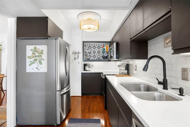 kitchen featuring backsplash, sink, crown molding, dark hardwood / wood-style flooring, and stainless steel appliances