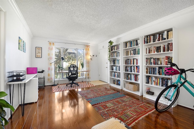 interior space featuring a textured ceiling, dark hardwood / wood-style floors, built in features, and ornamental molding