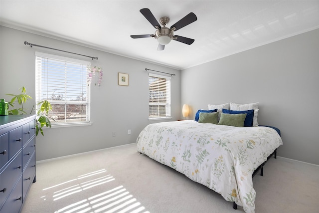 bedroom with light colored carpet, ceiling fan, and crown molding