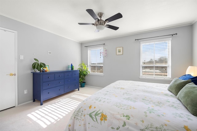 carpeted bedroom featuring multiple windows, ceiling fan, and crown molding