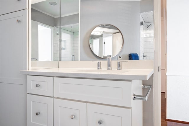 bathroom with crown molding, vanity, and walk in shower