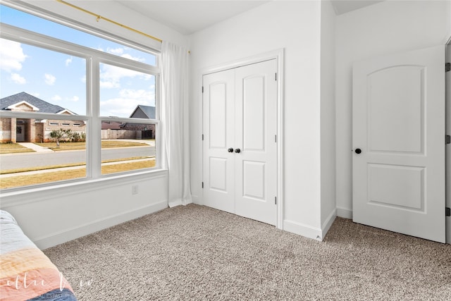 unfurnished bedroom with light carpet and a closet