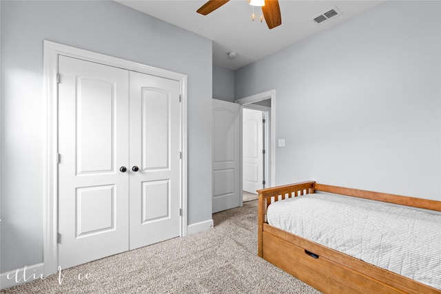 carpeted bedroom featuring ceiling fan and a closet