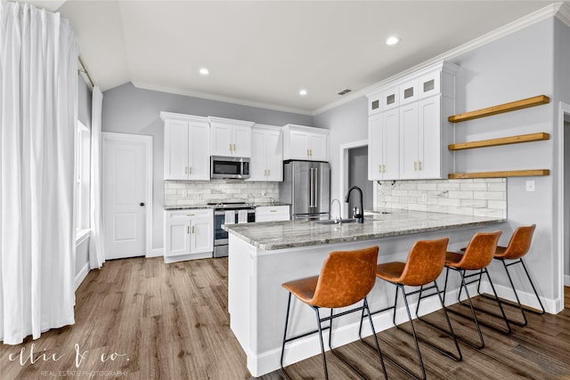 kitchen featuring white cabinets, backsplash, sink, and stainless steel appliances