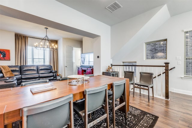 dining room with hardwood / wood-style flooring and a notable chandelier