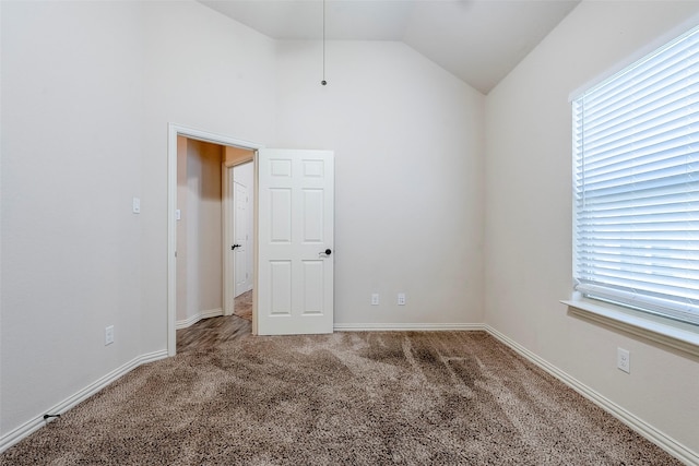 carpeted spare room with lofted ceiling