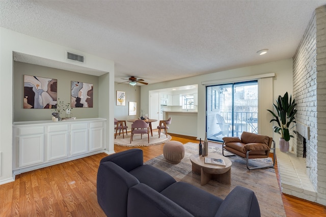 15151 Berry Trl Unit 1104, Dallas, TX 75248 - living area with ceiling fan, light wood finished floors, a textured ceiling, and visible vents