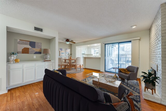 15151 Berry Trl Unit 1104, Dallas, TX 75248 - living room with ceiling fan, a textured ceiling, visible vents, and light wood-style flooring