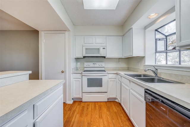 kitchen featuring white cabinetry, dishwasher, sink, electric stove, and light wood-type flooring