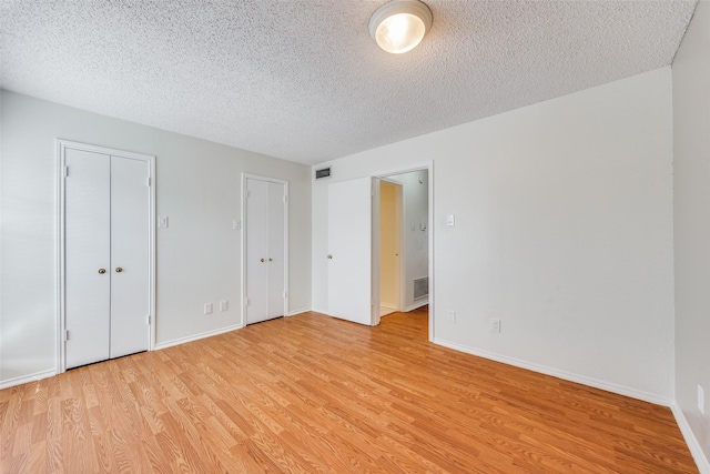 unfurnished bedroom featuring light wood-type flooring and a textured ceiling