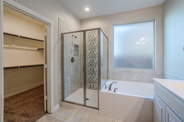 bathroom with tile patterned flooring, vanity, and separate shower and tub