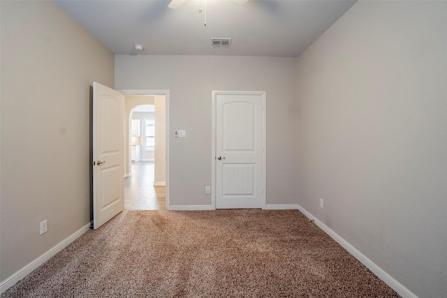 unfurnished room with ceiling fan and light carpet