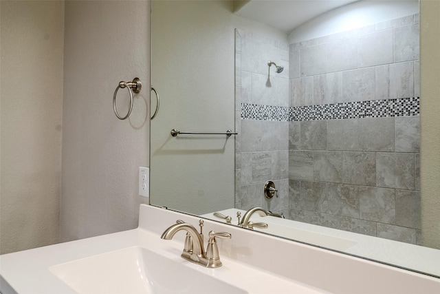 bathroom with vanity and a tile shower