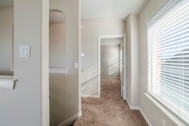 hall with light colored carpet