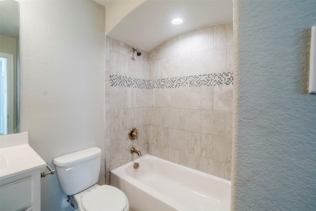 full bathroom with tiled shower / bath combo, toilet, and vanity