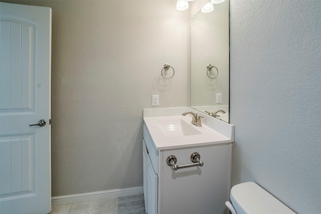 bathroom featuring tile patterned floors, vanity, and toilet