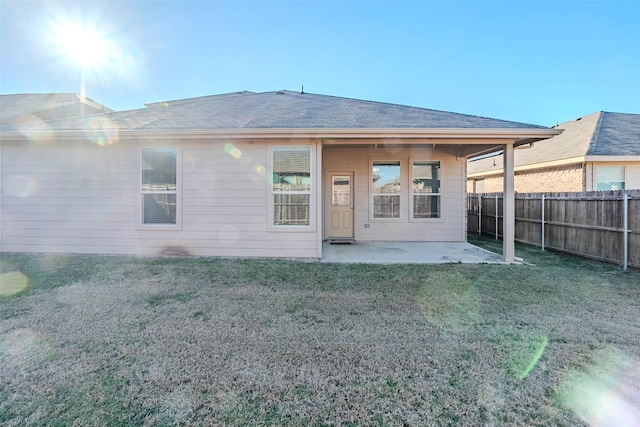 rear view of house with a yard and a patio