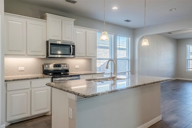 kitchen featuring sink, white cabinetry, stainless steel appliances, and hanging light fixtures