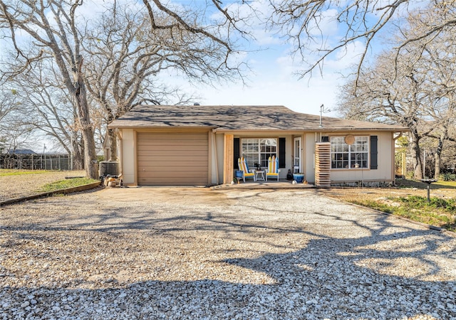 ranch-style home featuring covered porch and a garage