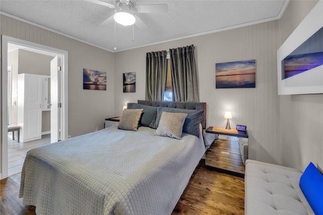 bedroom with hardwood / wood-style floors, a textured ceiling, ceiling fan, and ornamental molding