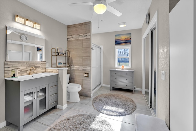 bathroom featuring vanity, backsplash, tile patterned floors, ceiling fan, and toilet