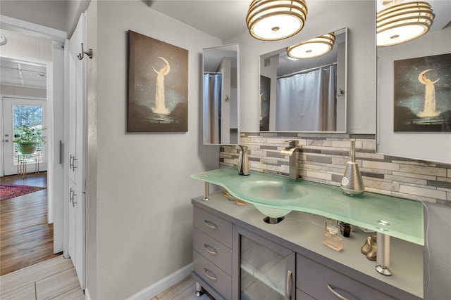 bathroom with vanity, backsplash, hardwood / wood-style flooring, and walk in shower